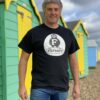 Male model posing on the beach wearing a black Filtrate oil t-shirt